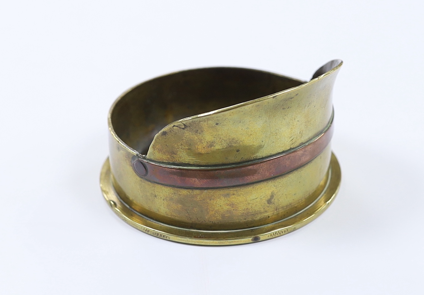 A First World War trench art worked brass cartridge case in the form of a peaked cap